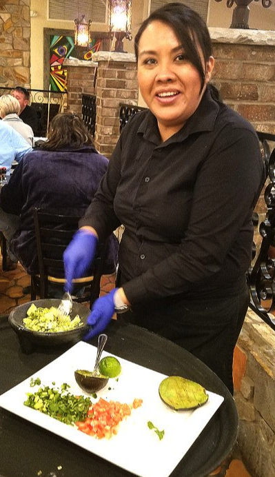 A woman making fresh guacamole tableside at Plaza Del Sol in Wilkesboro